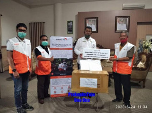 Bupati Touna saat terima bantuam APD dari Menager WVI Touna