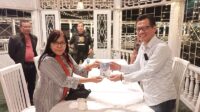 Tim Pokja Dewan Pers Rita Sitorus memberikan kenang-kenangan berupa buku saku wartawan kepada kepala Dinas Kominfo Kota Kotamobagu Fahri Damopolii