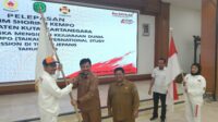 Sekda Kukar Sunggono menyerahkan bendera kepada Ketua Perkemi Kukar Ahmad Zulfiansyah pada acara pelepasan atlet Kempo, Selasa (3/10/2023)