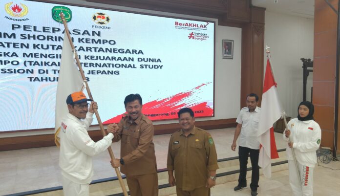 Sekda Kukar Sunggono menyerahkan bendera kepada Ketua Perkemi Kukar Ahmad Zulfiansyah pada acara pelepasan atlet Kempo, Selasa (3/10/2023)