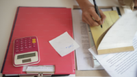 https://unsplash.com/photos/a-person-writing-on-a-piece-of-paper-next-to-a-calculator-5Dk_4uYj-BM